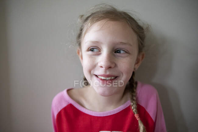Rindo menina loira com tranças francesas olha fora da câmera — Fotografia de Stock
