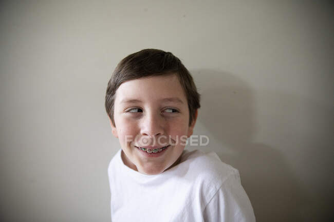 Gros plan Portrait de Tween Boy avec des bretelles souriant regardant hors caméra — Photo de stock