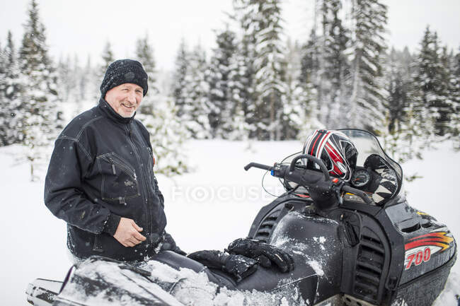 Retrato del anciano jubilado en moto de nieve durante el invierno. - foto de stock