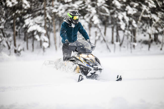 Hombre en casco motos de nieve en la columbia británica - foto de stock