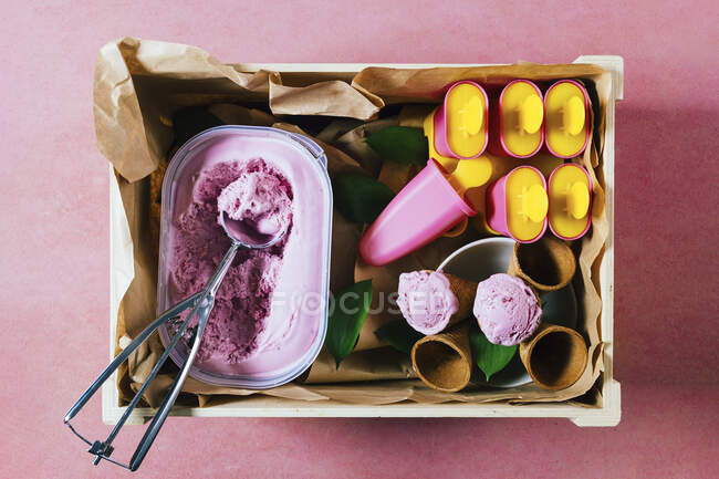 Delicioso sorvete de morango e gelados refrescantes em uma caixa de madeira rústica. Sorvete pronto para comer em um dia de verão ao ar livre. — Fotografia de Stock