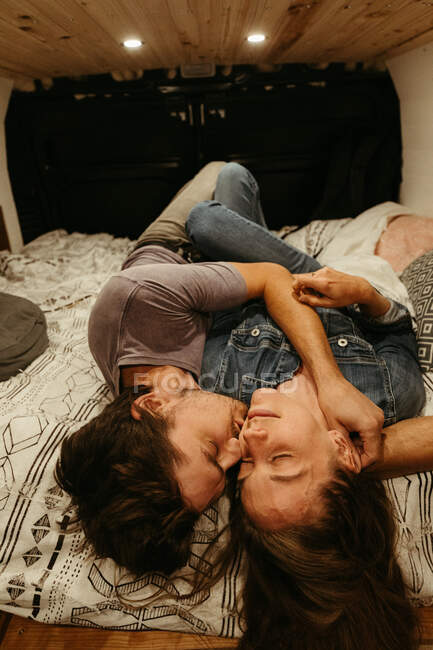 Intimate moment as newly engaged couple lay on bed together for kiss — Stock Photo