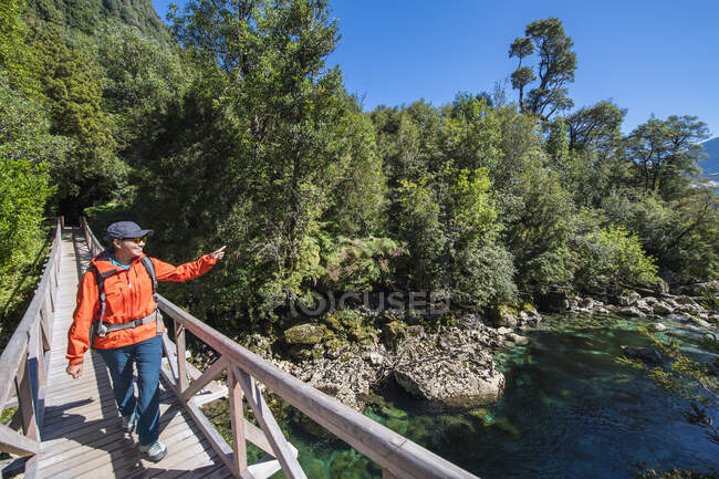 Woman crossing wooden bridge at Caleta Gonzalo in Chile — Stock Photo