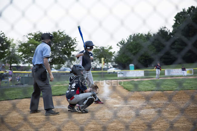 Wide rear view of a teen boy at bat during the baseball game — Stock Photo