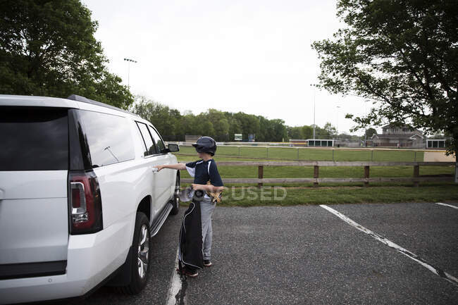 Side View of Teen Boy in Baseball Gear Opening SUV Door After Game — Stock Photo