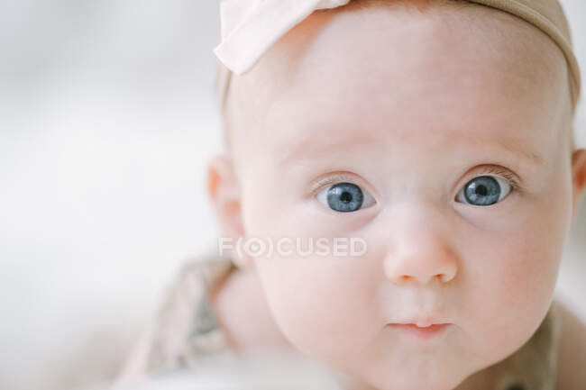 Gros plan de bleu yeux bébé fille regardant caméra — Photo de stock