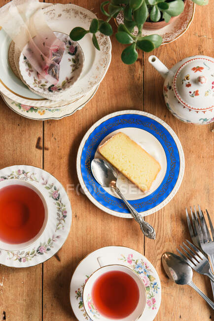 Overhead of tea time at a cafe with cake and teapots — Stock Photo