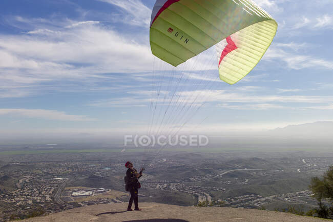 Homem testes levantar do vento antes de saltar para parapente paraquedas — Fotografia de Stock