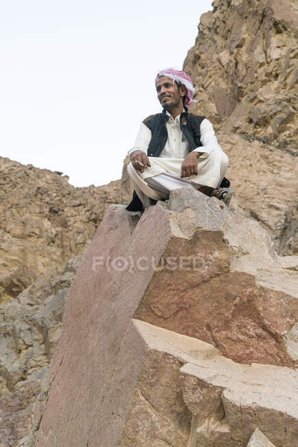 Um beduíno sentado em uma rocha nas montanhas perto de nuweiba — Fotografia de Stock