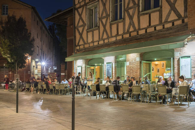 Artista caffè e bar nel centro storico di Tolosa di notte lungo il fiume — Foto stock