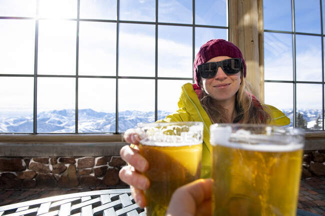 A woman toasting to a day on the slopes. — Stock Photo