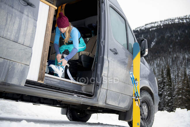 Una mujer preparándose para un día de esquí de fondo. - foto de stock