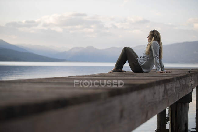 Eine Frau genießt einen Abend auf den Docks am Hebgensee. — Stockfoto