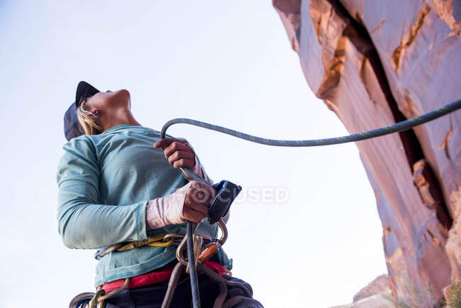 Una donna che difende il suo compagno di arrampicata nel deserto. — Foto stock