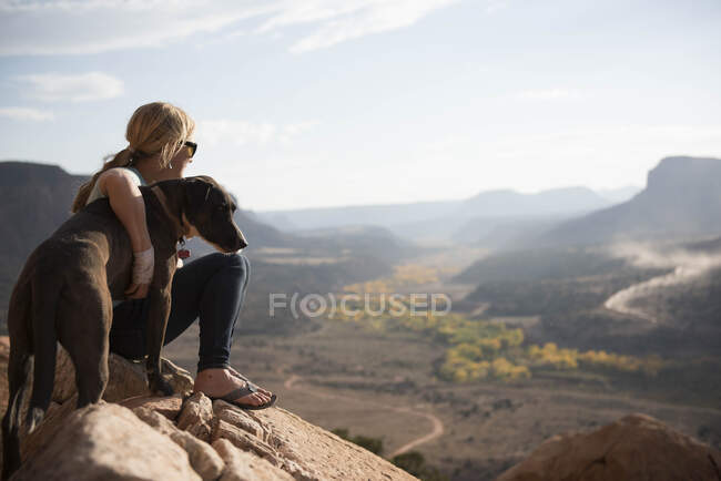 Eine Frau und ihr Hund genießen die Aussicht auf die Wüste, utah — Stockfoto