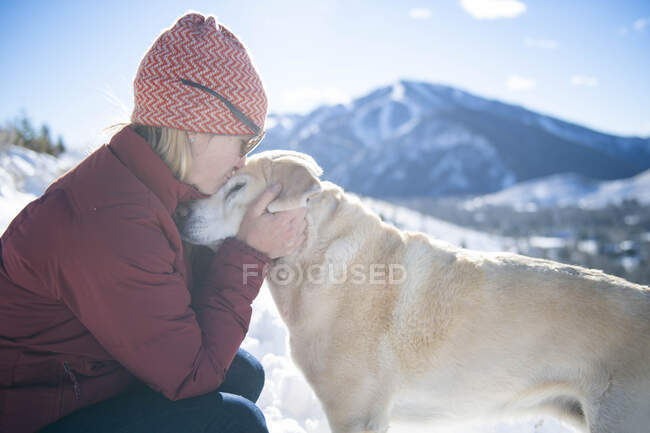 Eine Frau gibt ihrem Hund einen liebevollen Kuss. — Stockfoto