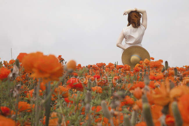 Червона волохата жінка в помаранчевих квітах — стокове фото