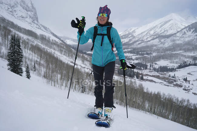 Frau rast in der Nähe von Gothic, Colorado, bergauf, um Ski zu fahren. — Stockfoto