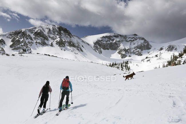 Dos mujeres esquian en el Monte Sopris con un perro en Colorado - foto de stock