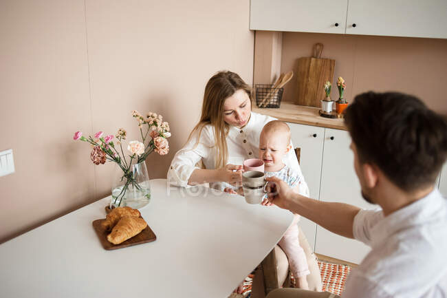 Glückliche Familie mit ihrer kleinen Tochter in der Küche. — Stockfoto
