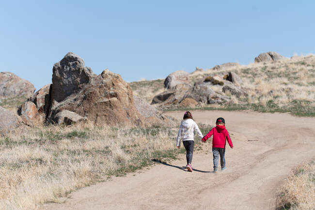 Crianças caminhadas na estrada de terra — Fotografia de Stock