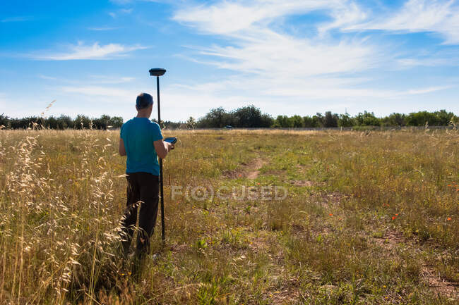Геодезист, работающий с прибором GPS и получающий данные с поверхности — стоковое фото