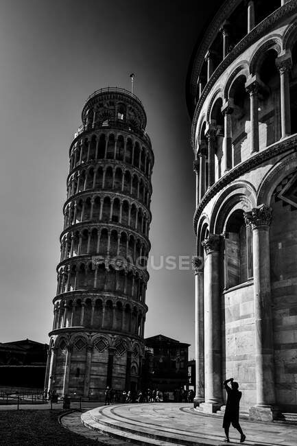 Torre pendente di Pisa su bianco e nero con turista che scatta una foto — Foto stock