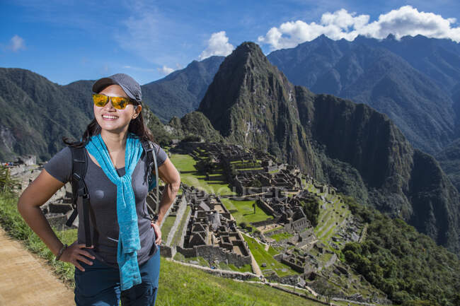 Frau in Inka-Ruinen blickt lächelnd in die Kamera, Machu Picchu, Peru — Stockfoto