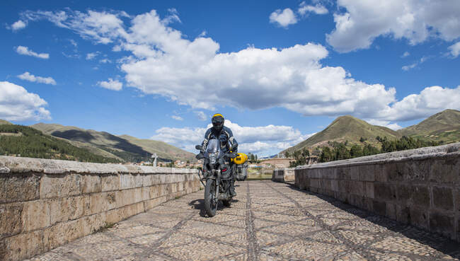 Conducción de motos sobre un puente del río Urubamba, Cusco, Perú - foto de stock