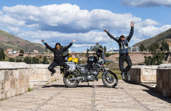 Велосипедисти, які святкують на мосту через річку Урубамбу (Перу). — стокове фото