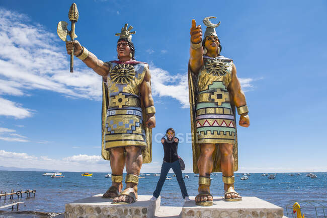 Donna in posa alle statue di Dio Sole e Dea della Luna, Lago Titicaca — Foto stock