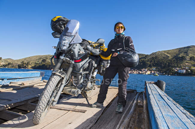 Woman and her touring motorbike on simple ferry crossing Lake Titicaca — Stock Photo