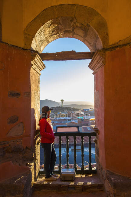Female tourist looking over Potosi rooftops from archway, Bolivia — Stock Photo
