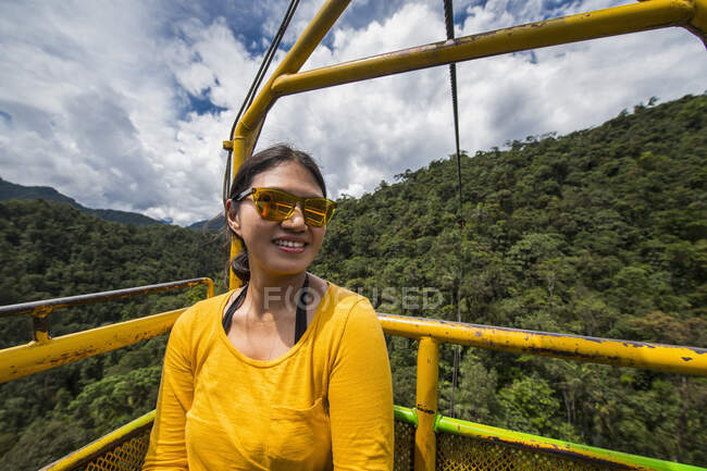 Woman taking a cable car ride at the waterfall in Mindo, Ecuador — Stock Photo