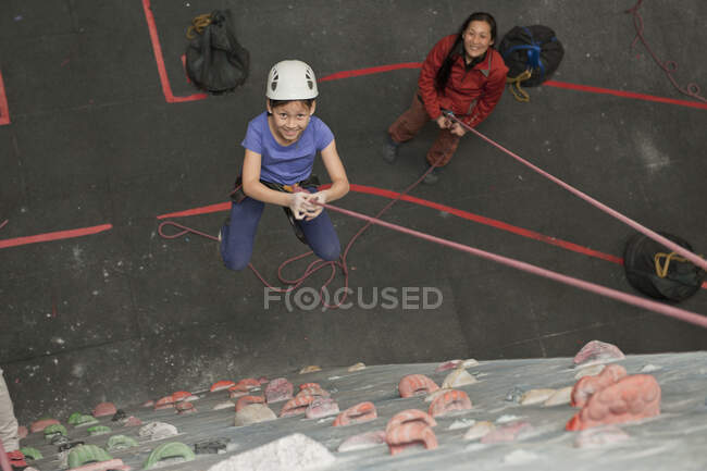 Daughter and mother having fun at indoor climbing wall in the UK — Stock Photo