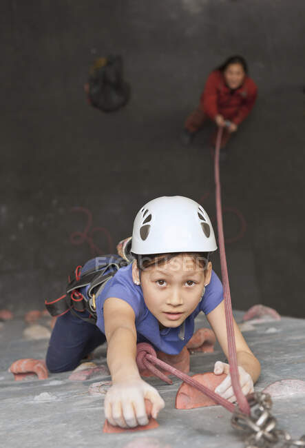 Giovane ragazza che si arrampica sulla parete di arrampicata al coperto in Inghilterra / Regno Unito — Foto stock