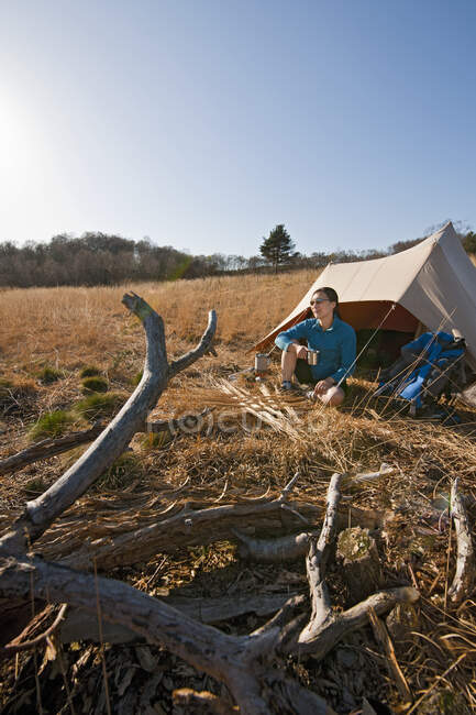 Женщина сидит перед хлопковой палаткой в Англии — стоковое фото