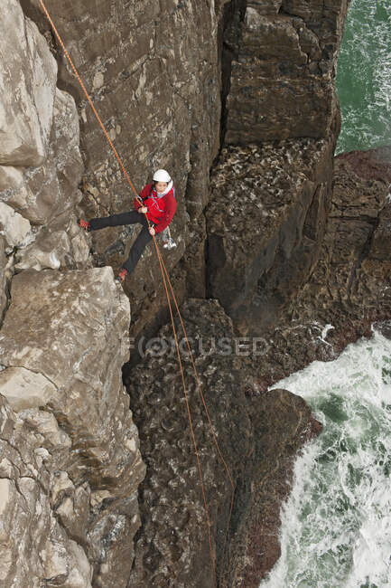 Femme grimpeuse descendant en rappel du seacliff à Swanage / Angleterre — Photo de stock