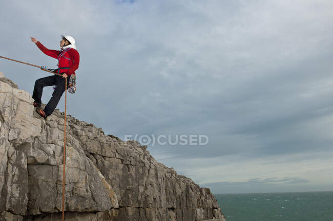 Female climber rappelling of seacliff in Swanage / England — Stock Photo