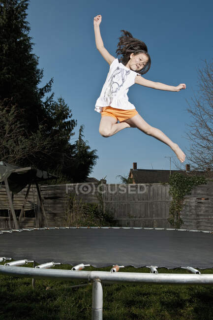 Young girl jumping on trampoline in Woking - England — Stock Photo