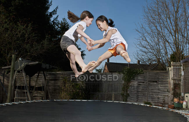 Дві молоді дівчини стрибають на батуті в Вокінгу (Англія). — стокове фото