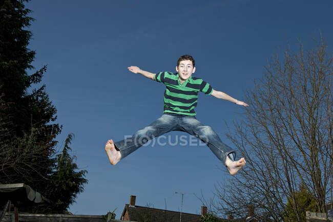 Boy jumping on trampoline in Woking - England — Stock Photo