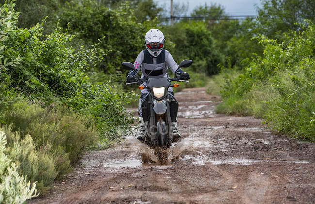 Mulher dirigindo sua moto na estrada de terra na Tailândia — Fotografia de Stock