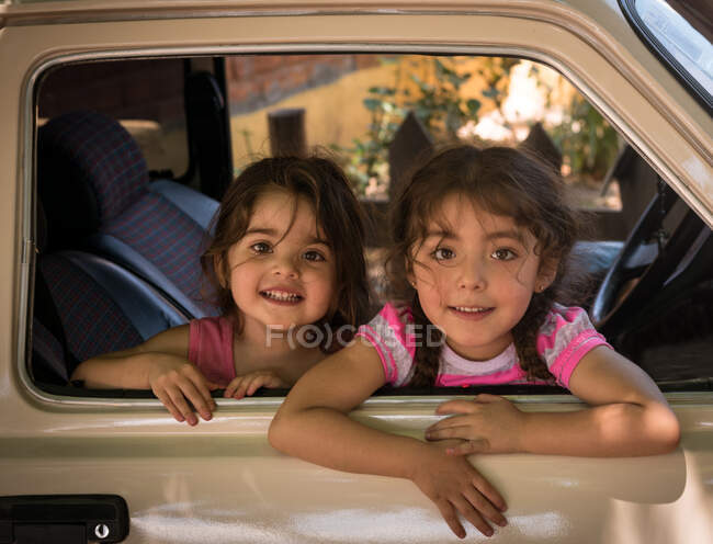 Niñas sonriendo en un coche - foto de stock