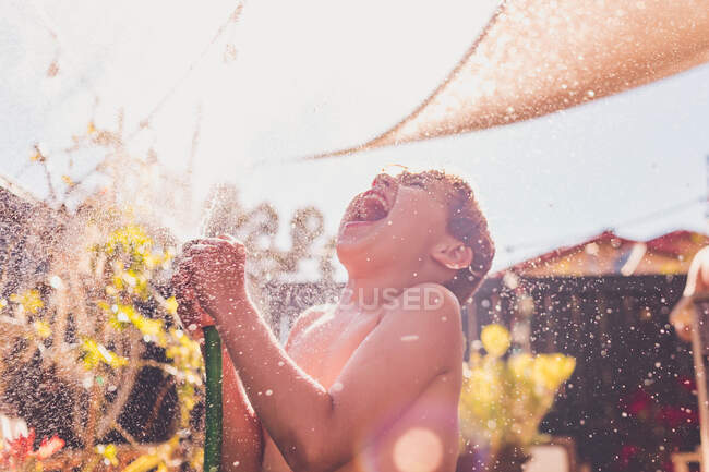 Grande sorriso giocando con un tubo in una giornata calda — Foto stock