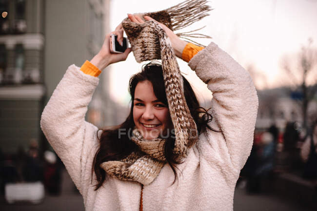 Retrato de menina adolescente feliz em roupas quentes em pé na cidade — Fotografia de Stock