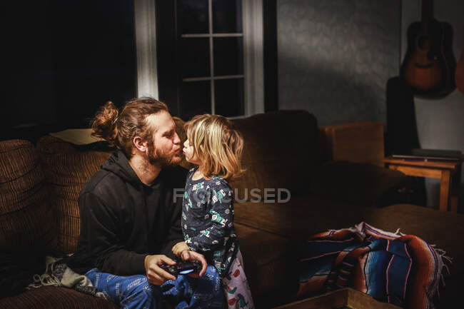 Pequeño niño besando a su padre buenas noches - foto de stock
