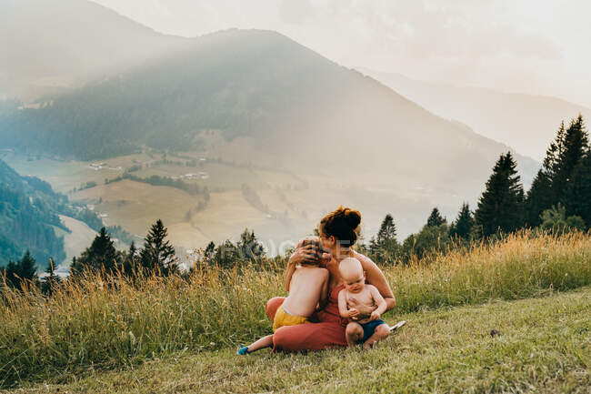 Happy young mother with children in the mountains — Stock Photo