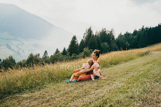 Felice giovane madre con bambini in montagna — Foto stock