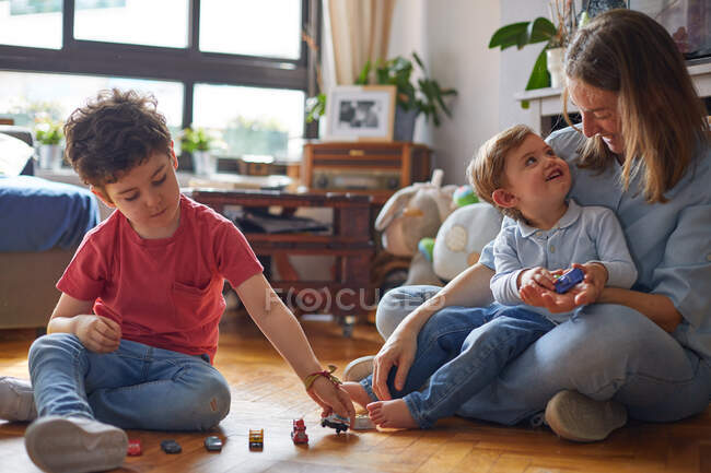 Crianças felizes e sua mãe brincando com brinquedos — Fotografia de Stock